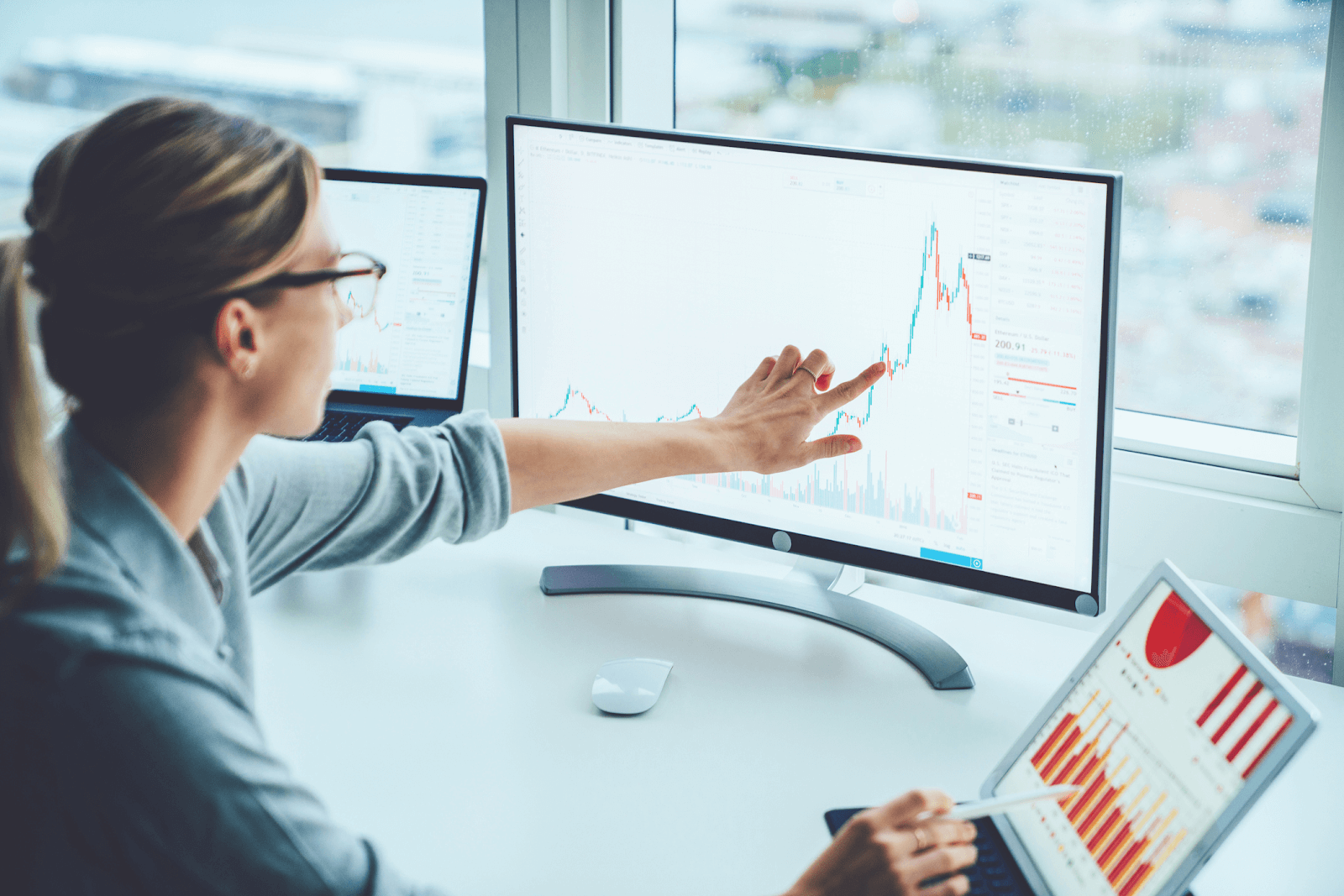 Professional with a desktop and tablet using financial process automation