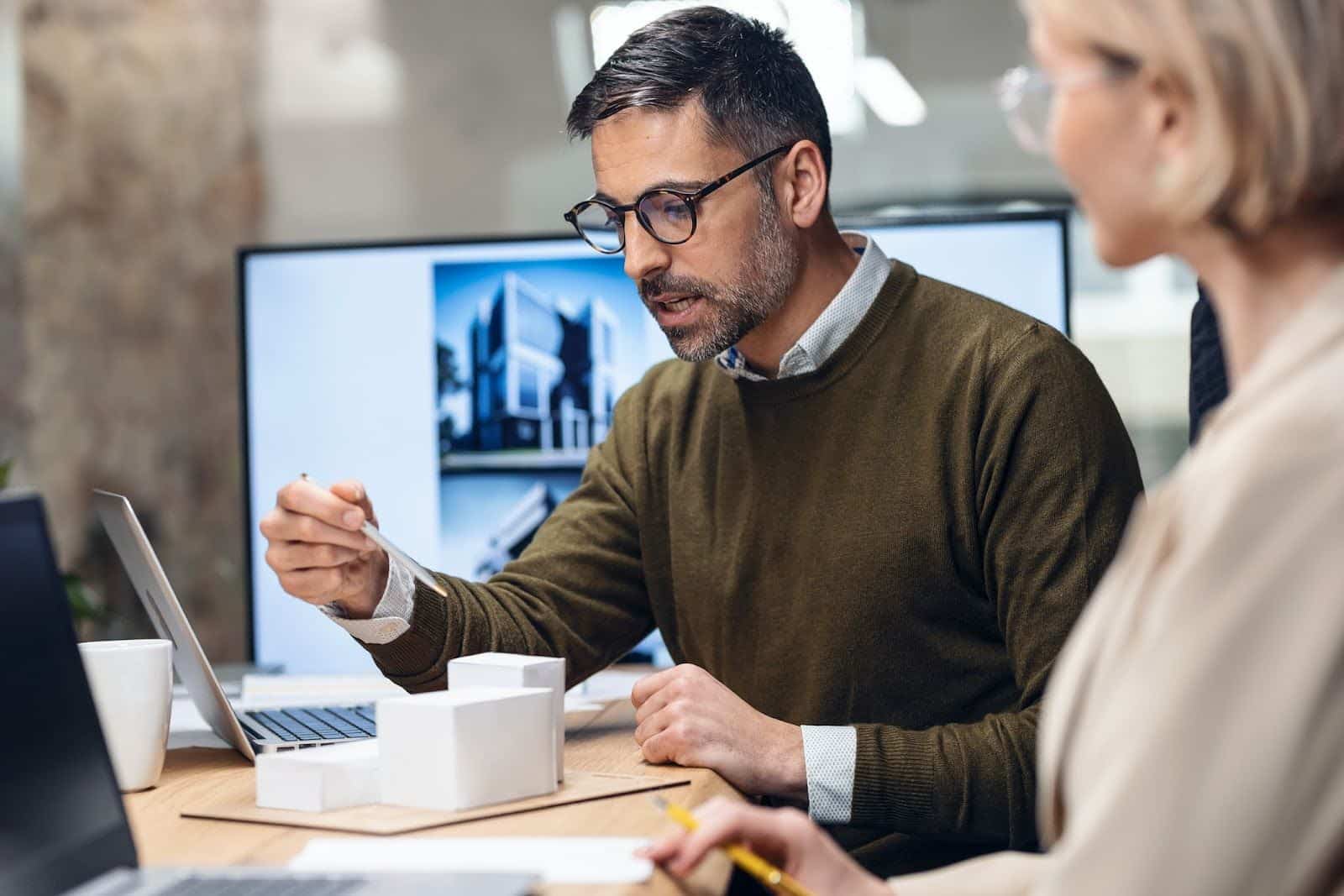 Man and Woman Architecture Project Planning and Considering Deltek Vison vs Vantagepoint