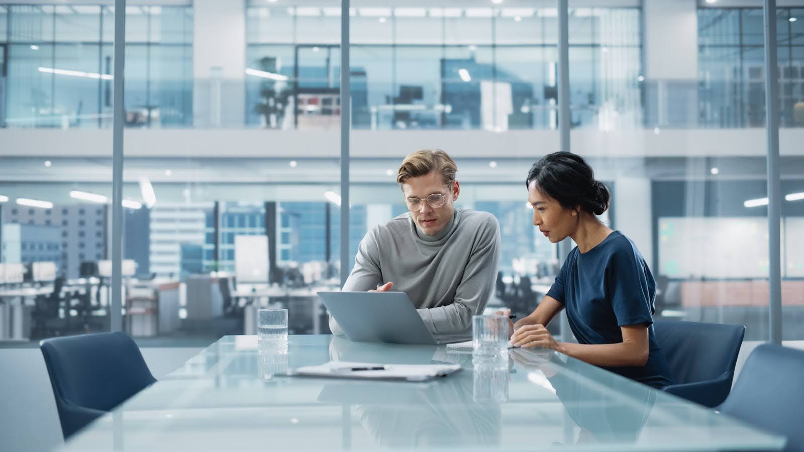 Two coworkers looking at Deltek CRM on laptop