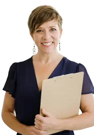 A woman with short brown hair, wearing a dark blouse, smiles while holding a clipboard in front of her.