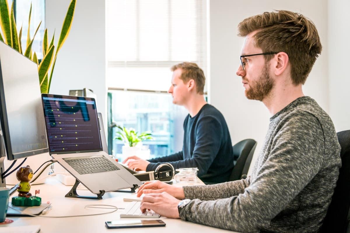 Team managing overtime data at computer screens