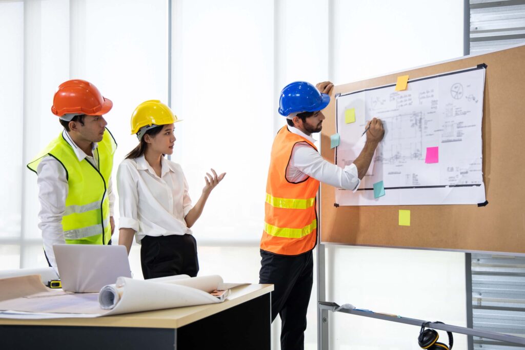 Engineers reviewing building plans to align planned vs actual project outcomes